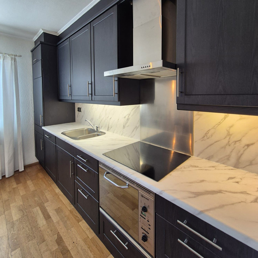 Deze klassieke keuken kreeg een moderne make-over. De combinatie van CT58 Faded Grey Wood en NE31 Mat White Marble zorgt voor contrast en rust. Dankzij zorgvuldig vakmanschap oogt de keuken als nieuw!