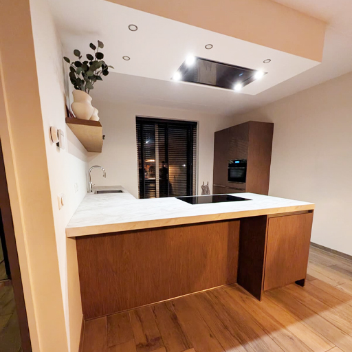 Keukenwrap in Kampen met fronten in AA14 Original Oak en een werkblad in NE70 Mat Beige Marble. De combinatie van warme houtlook en licht marmer zorgt voor een moderne, rustige en luxe uitstraling die perfect in balans is.