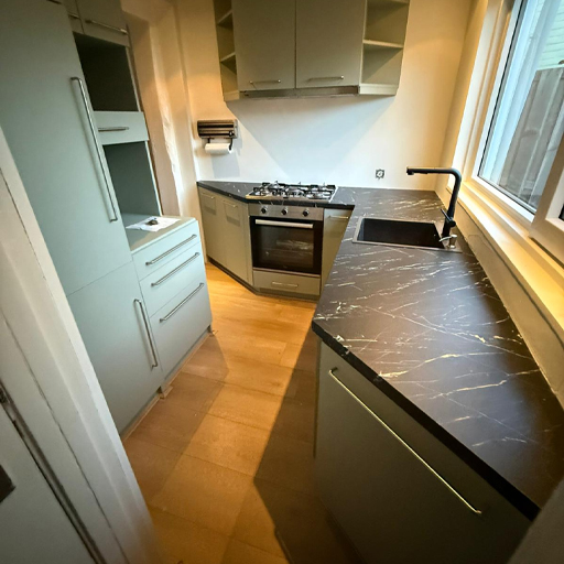 In deze keuken in Zwolle zijn zowel de fronten als het aanrechtblad gewrapt. De combinatie van olijfgroen en zwart marmer geeft de keuken een rustiger en luxer geheel, dat warm en eigentijds oogt en perfect past bij de ruimte.